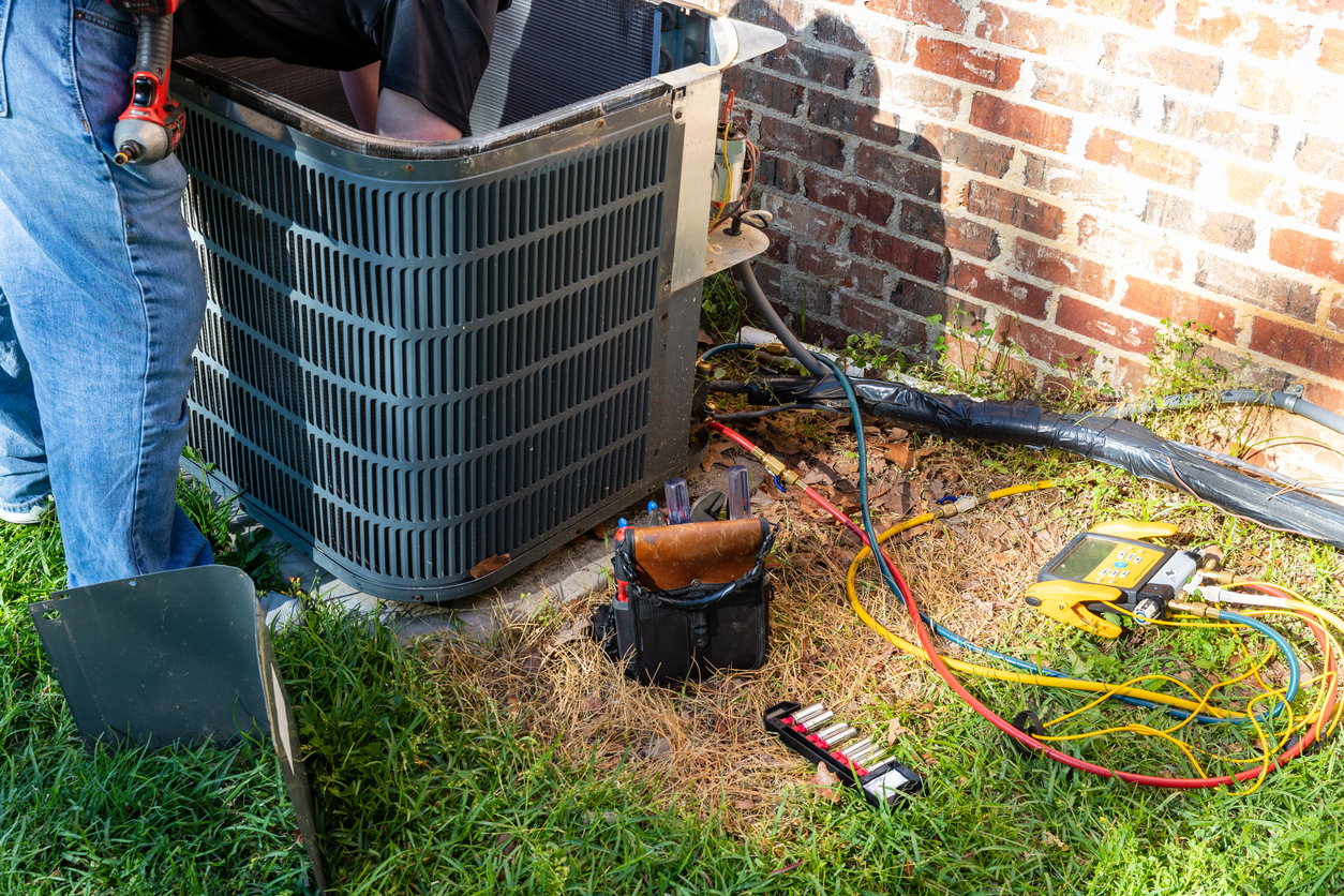 HVAC technician performing a service on an outdoor AC unit