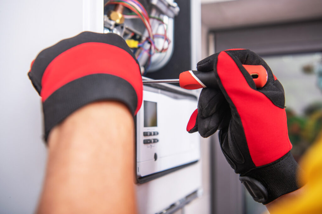 HVAC technicians hands repairing a residential heating system