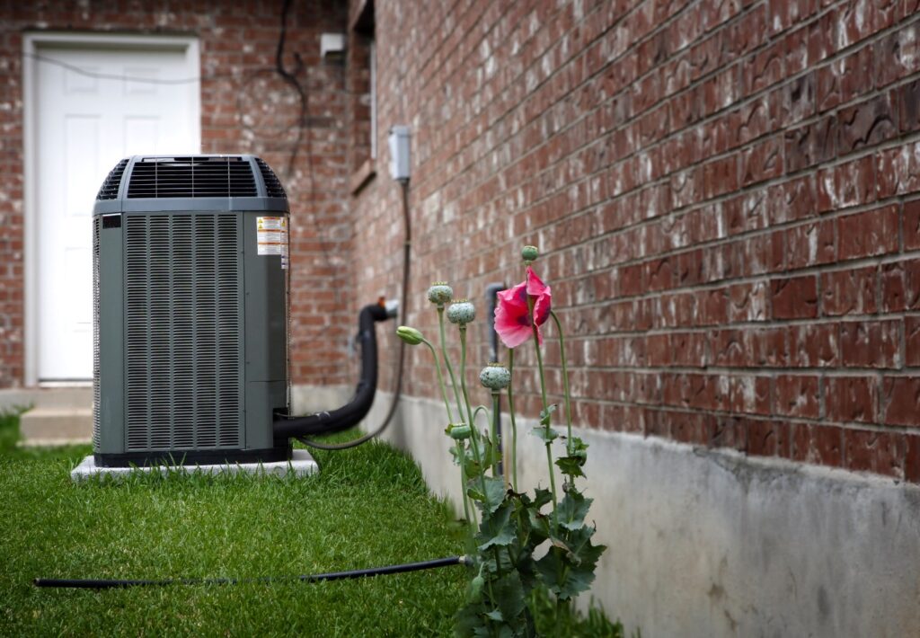 HVAC unit outside a home in a grass backyard