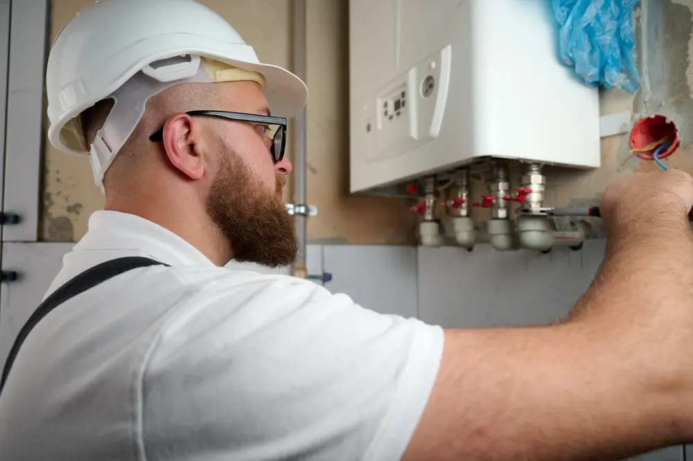 A plumber installing a boiler. Boiler installation service