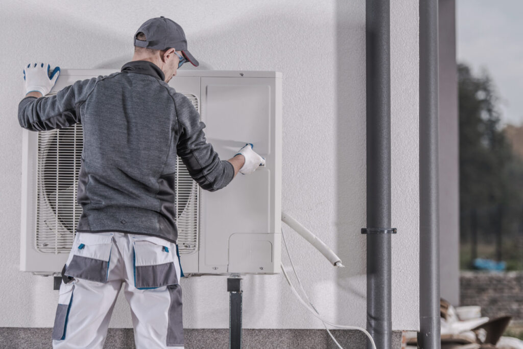 HVAC technician repairing a residential heat pump in Mount Pleasant, WI