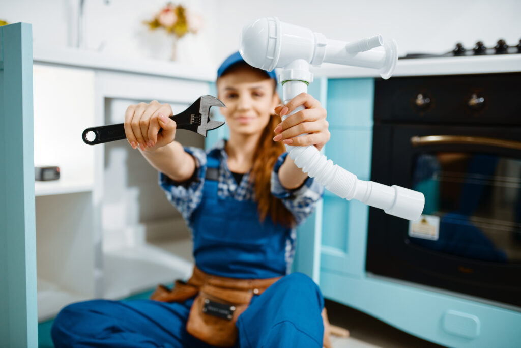 Young female plumber in uniform 